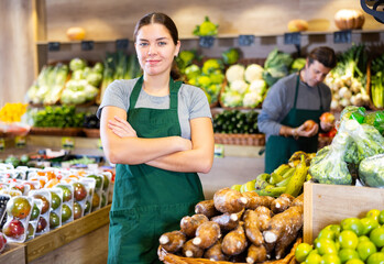 Saleswoman near fruit and vegetables stalls offering to buy yuca