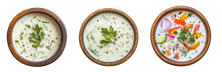 Top view of Indian raita in wooden bowls with herbs and vegetables, isolated on transparent or white background, refreshing yogurt-based side dish for curries and biryani