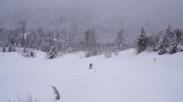 Snowboarder descends from a snow-covered mountain along the ski lift