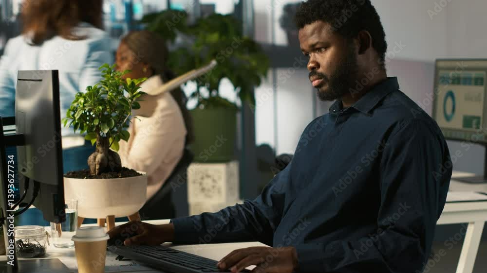 Poster accountant in modern office using mobile phone to text friends after inputting data on computer. emp