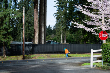 City parks and recreation worker using a gas powered trimmer to cut down grass in roadside drainage...