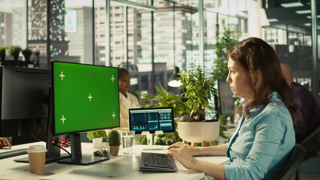 Green screen PC in office used by employee working on company administrative tasks. Mockup computer display on desk used by worker reviewing business data metrics, camera B