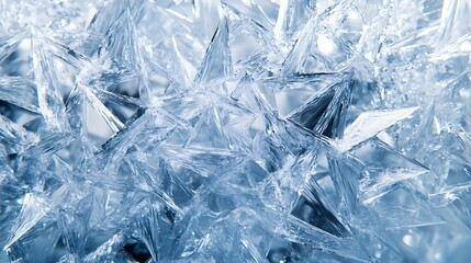 Close-up of intricate ice crystal formations creating a stunning natural pattern in shades of blue and white, illuminated to enhance the sparkling texture