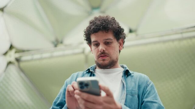 Close-up, man looks at google map on mobile phone and looks around on modern city background