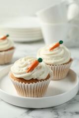 Delicious carrot cupcakes on white marble table, closeup