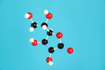 Molecule of vitamin C on light blue background. Chemical model