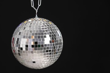 One shiny disco ball on black background, space for text