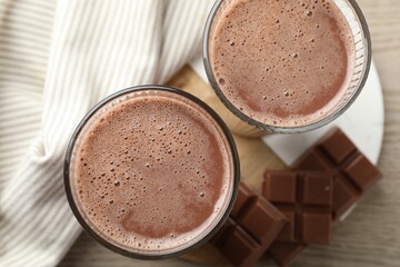 Tasty chocolate milk and bars on wooden table, top view