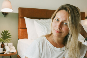 Portrait of beautiful blonde woman in bedroom