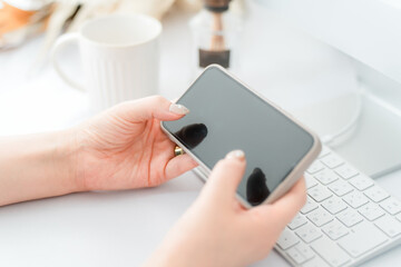 スマホ・スマートフォンの横向きの画面を見るネイルをした女性
