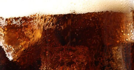 Pouring refreshing cola into glass with ice cubes against white background, closeup