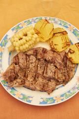 Grilled beef tenderloin steak with delicious golden potatoes and corn