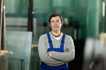 Fototapeta premium During work process, man employee produces blanks for repairs and interior decoration. He carries out installation work, products for renovation of residential premises made of glass and plastic.