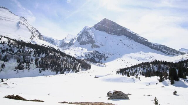 Offroad car driving across winter mountain landscape, wide establisher