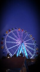 Roda gigante com cores vibrantes ao anoitecer