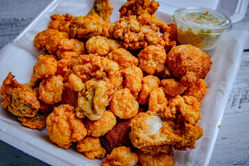fried seafood mixed in a white plate with a side of salad.