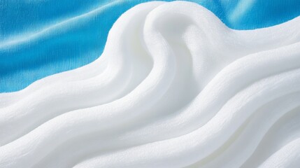 Obraz premium Soft, wavy white fabric contrasts with a textured, cool blue background. Serene
