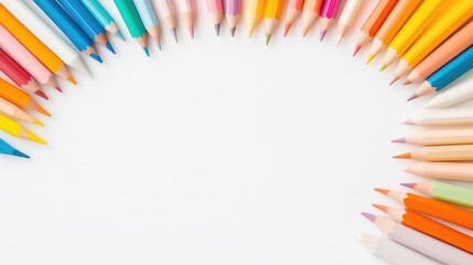Fototapeta premium Colorful pencils arranged in a semi-circle on a white background, showcasing vibrant hues and creative composition, and top view.