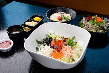 A set meal of raw fish rice topped with various vegetables and chopped raw fish
