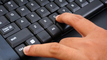 Close up on finger pressing ctrl or control and c or ctrl + c shortcut keys on a computer keyboard...
