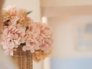 bouquet of pink roses. Beautiful bunch of artificial flower in wooden basket. Famous decoration interior design in restaurant.