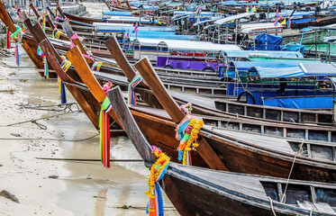 Row of longtail boats beached on the shore of Koh Phi Phi, Thailand. 

