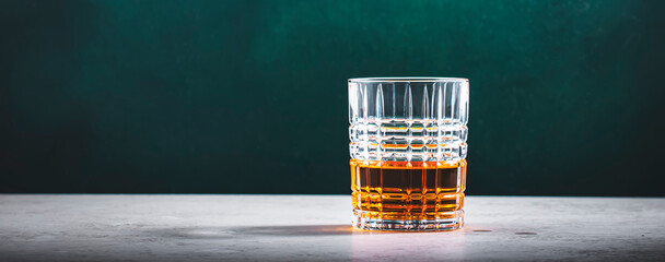 Blended irish whiskey in glass on dark green background
