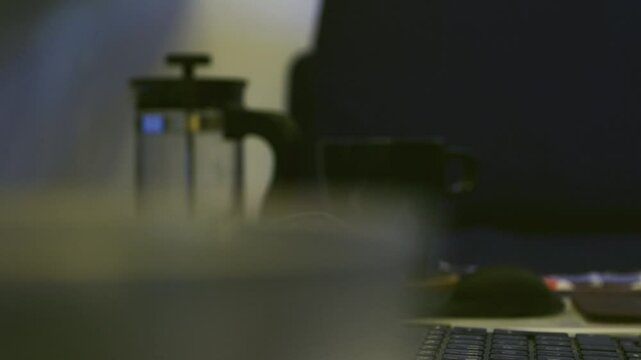 Pulling focus from a glass to a coffee presser.