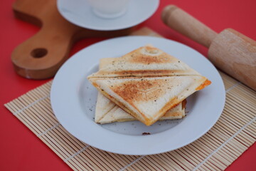a plate of toasted sandwich triangles neatly stacked on a white plate