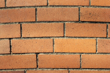 Brown brick wall with a curved pattern close-up abstract textured background