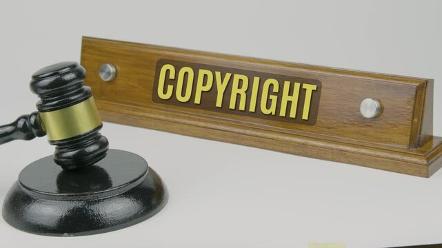 "Copyright" text on a nameplate beside a gavel, symbolizing the legal protection of creative works and the rights of authors and creators to control the use of their intellectual property