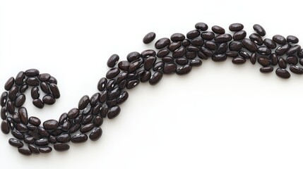 Close-Up View of Black Beans Arranged in a Creative Swirling Pattern on a White Background
