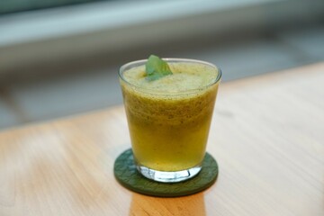Fresh and healthy juice blend on the table. Ingredients are Basil, apple, lime, orange and honey....