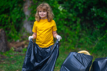 Child boy picking up plastic bottle outdoor. Save environmental and reduce waste concept. Recycle...