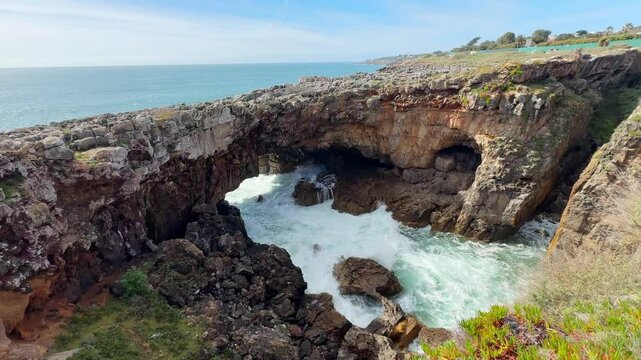 Rocks on the coast of Atlantic ocean in Cascais, Portugal. Boca do Inferno cave on the west coast of Cascais. Waves crashing on the rocks. Famous travel destination
