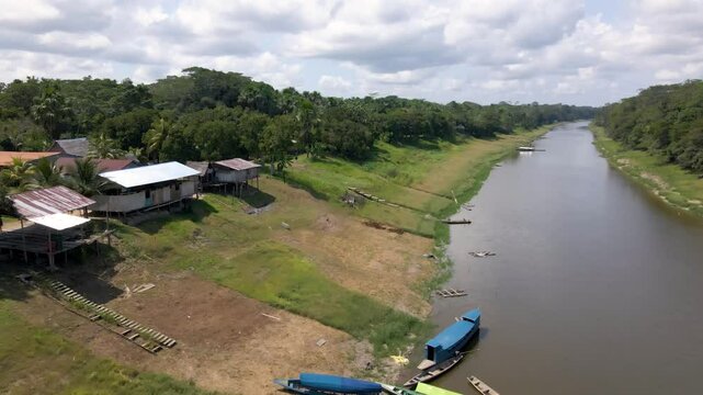 Scenic aerial pullback along coastal riverbank in Buenos Aires community in Pacaya Samiria Reserve in Loreto, Peru, sunny day
