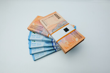 Stacks of Indonesian Rupiah Banknotes Arranged on White Background
