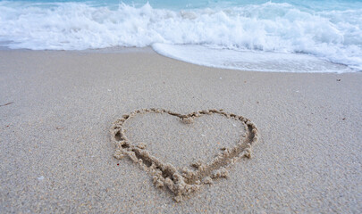 Ocean waves background. Tropical ocean waves. Blue seaside view. Heart drawn in sand. Waves forming a heart shape sign. Love on beach. Romantic summer. Heart made of sand. Love and ocean waves.