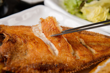 Lift a piece of grilled fish
