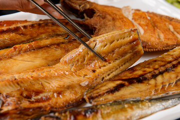 Lift a piece of grilled fish
