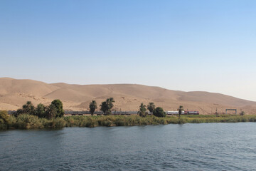 Landscape of the magical blue Nile River and a train in upper Egypt