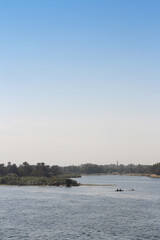 Landscape along the Nile River with fishermen in their rowing boat in the morning, Egypt