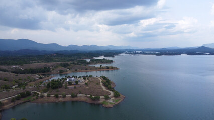 Fototapeta premium Aerial view of the rocky hill tourist or bukit batu attraction in the Riam Kanan Banjarbaru reservoir, which is surrounded by wide and beautiful waters