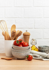Kitchen utensils, tomatoes and olive oil creating a rustic culinary scene