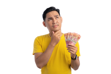 Pensive young Asian man touching his chin, holding money, looking up with doubtful expression isolated on transparent background