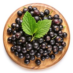 A wooden plate of freshly picked blackcurrants with vibrant green leaves