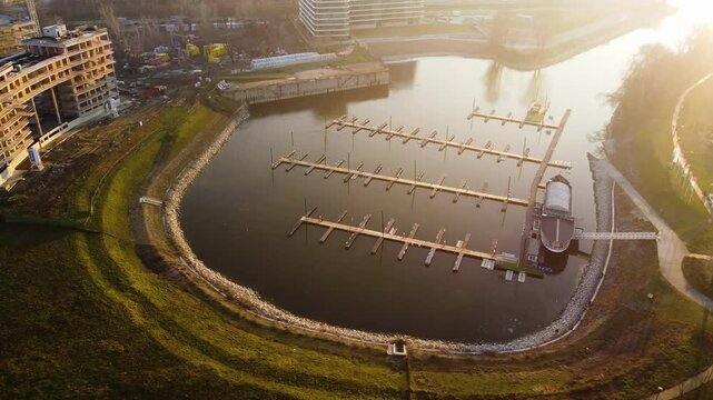Drone ascends over modern apartments with water and park overview near Foka-&ouml;b&ouml;l in Budapest