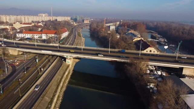Drone follows moving traffic on Arpad Bridge as it crosses Danube River in Budapest at dusk