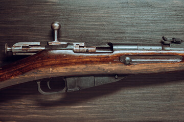 Soviet Mosin rifle detail on a wooden background, closeup. The weapon of the red army and the revolution. A vintage bolt carbine from World War II
