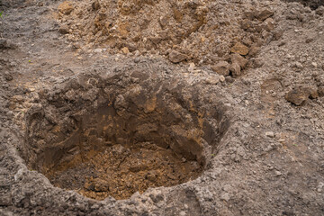 A round hole dug in the ground for planting trees in the spring. Garden preparation and planning
